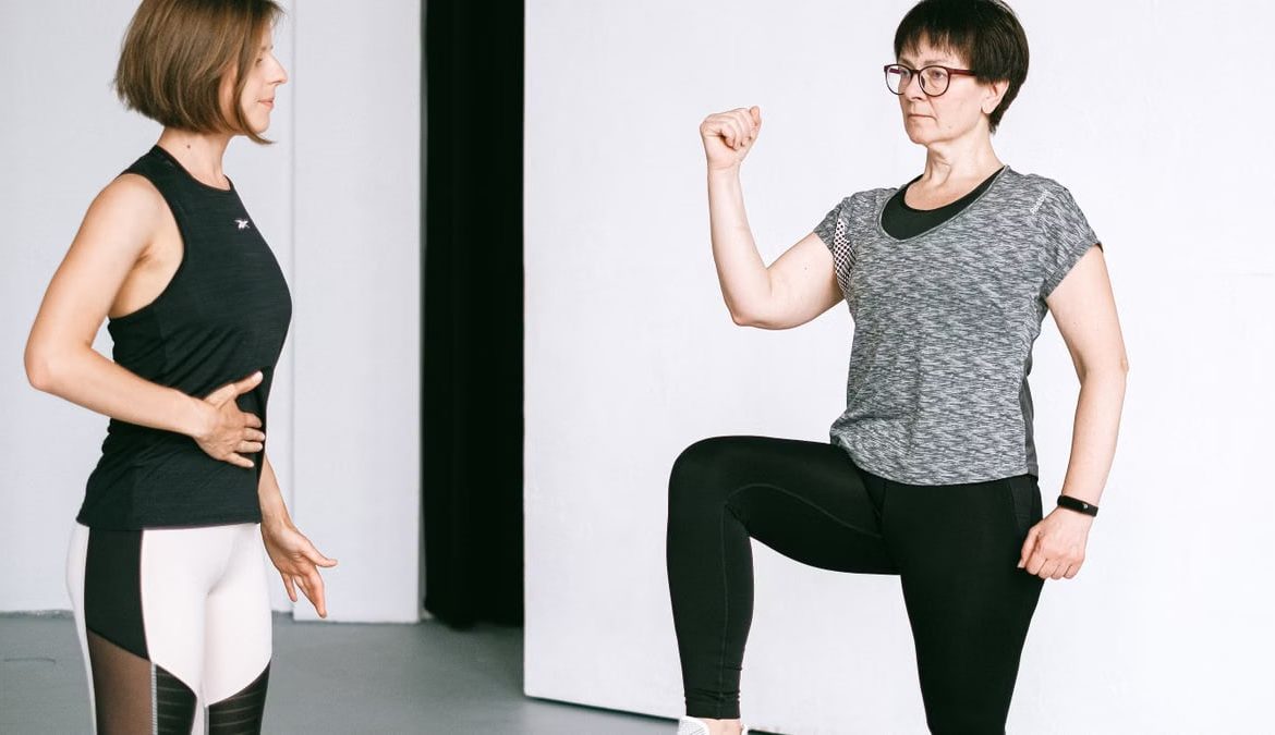 Two women working out together, demonstrating fitness exercises on a white background.
